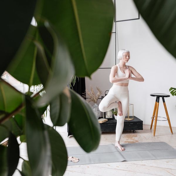 Shadow of a person practicing yoga on a white wall